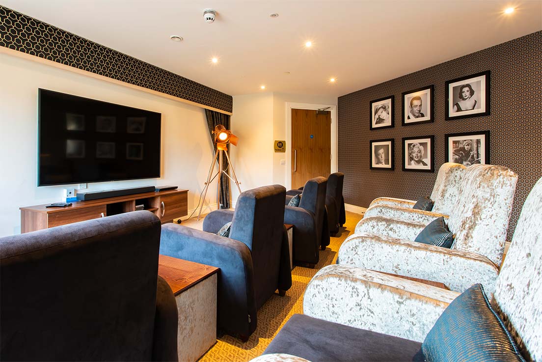 cinema screen in care home with large blue armchairs