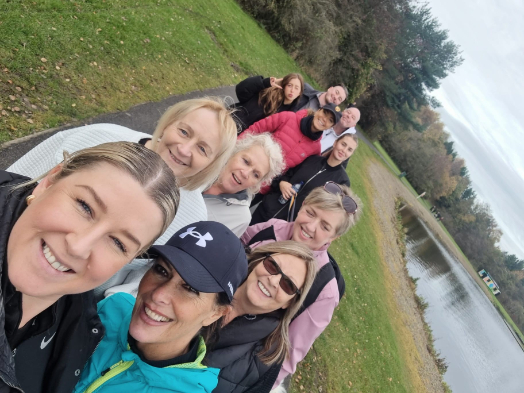 Bothwell Castle Care Home staff, residents’ families, and pets walking along a scenic path at Strathclyde Country Park during a 10k sponsored walk for Make-A-Wish UK