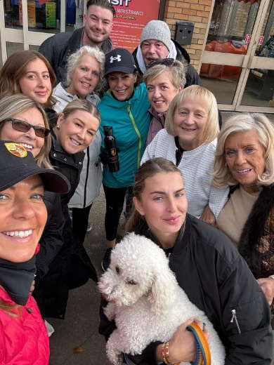 Bothwell Castle Care Home staff, residents’ families, and pets walking along a scenic path at Strathclyde Country Park during a 10k sponsored walk for Make-A-Wish UK