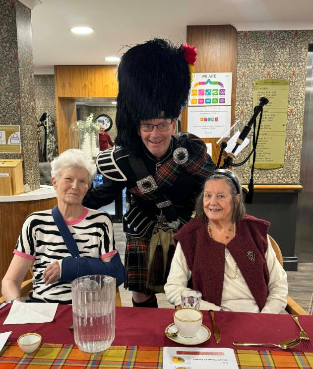 greg the piper with residents for burns day