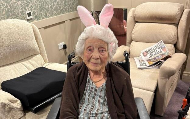 older lady sat down wearing easter bunny ears