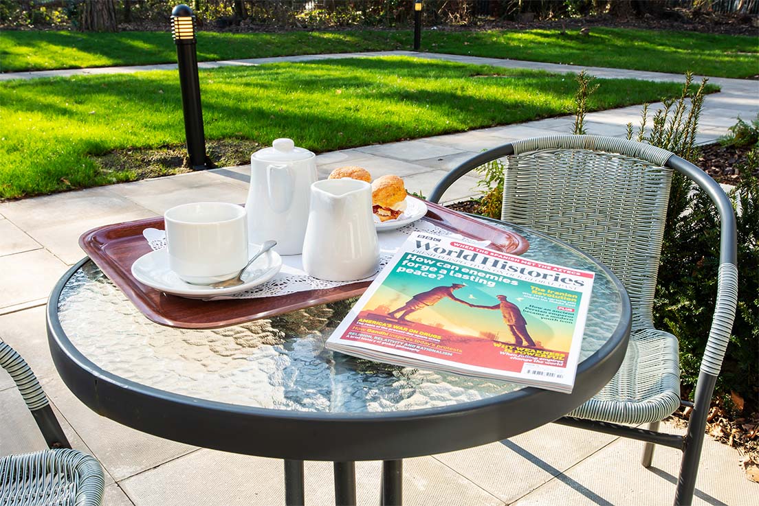 magazine and breakfast tray on an outdoor patio table