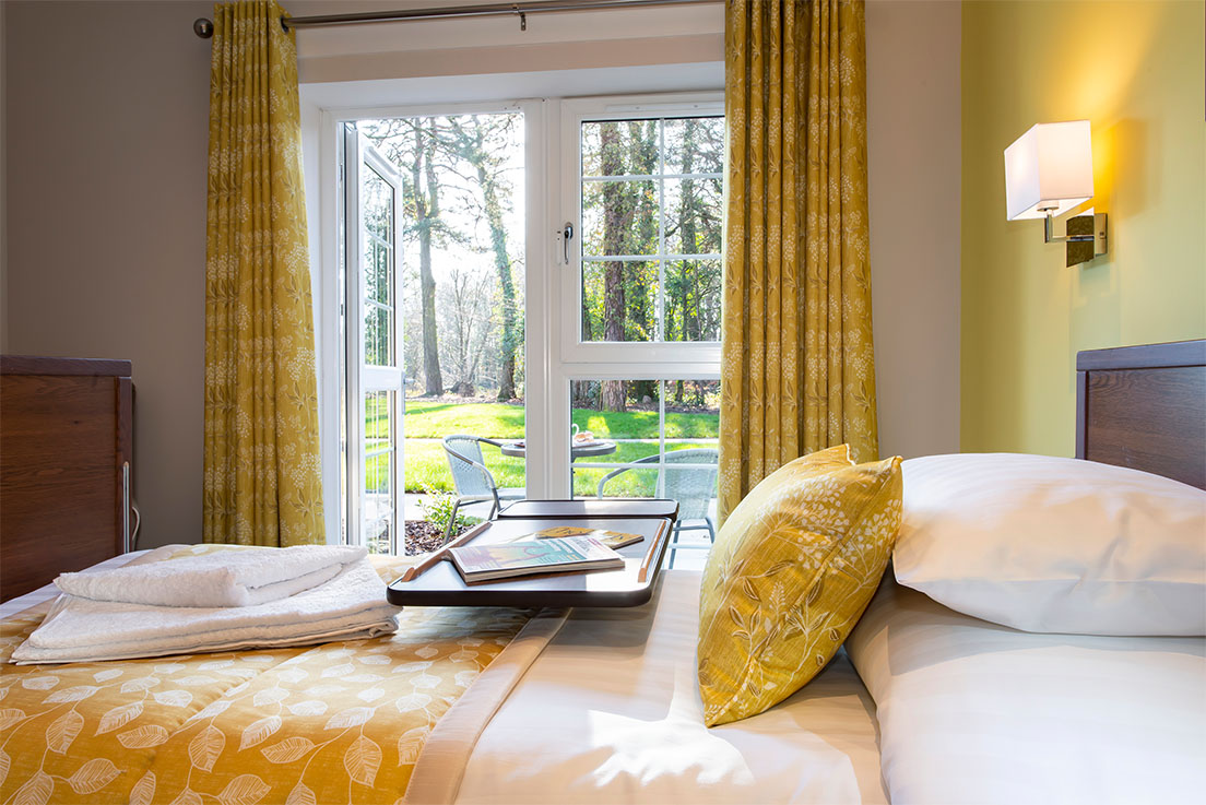 bedroom decorated yellow with adjustable table and large windows