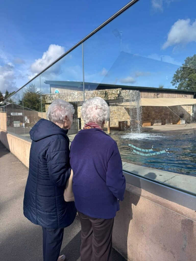 two elderly ladies looking at a water exhibit at the zoo